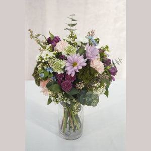 Purple spray mums, eucalyptus, and fresh, local flower arrangement in a glass vase