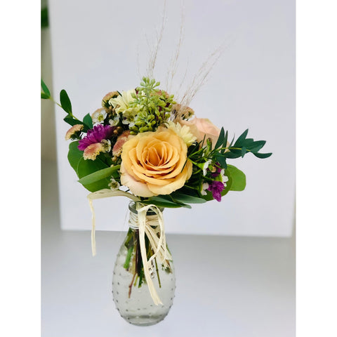 rose in a bud vase with greenery